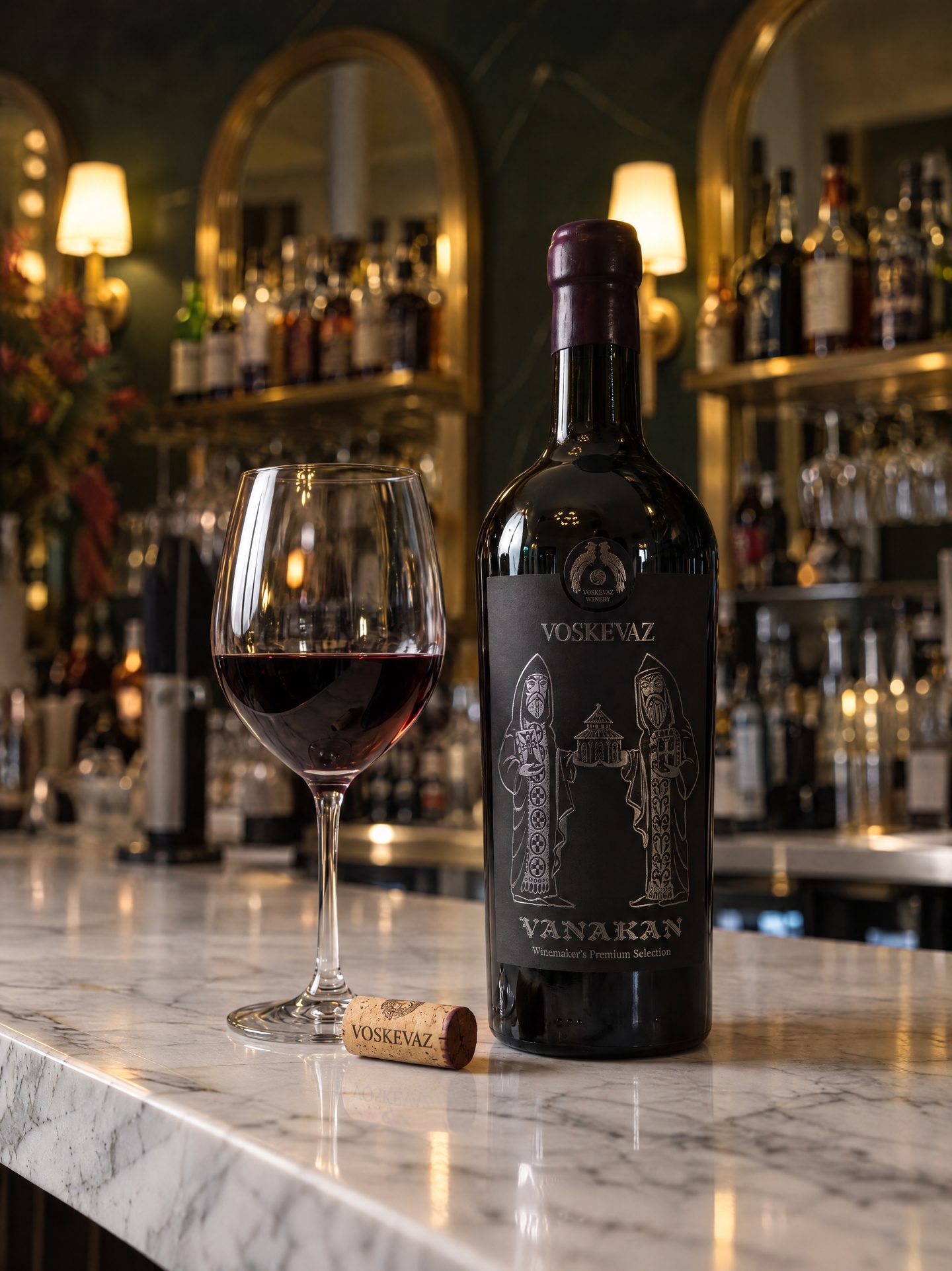 A bottle of Vanakan red wine beside a poured glass on the marble bar